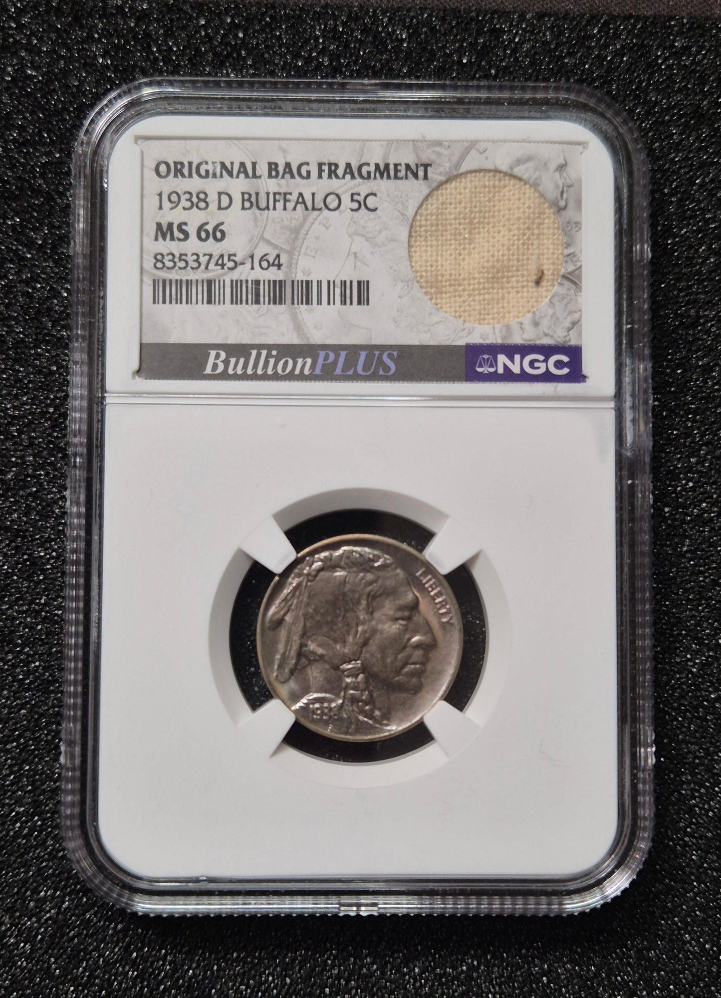1938-D Buffalo Nickel, MS66 by NGC and presented with a BullionPLUS “Original Bag Fragment” label that includes a small piece of an original U.S. Mint bag.